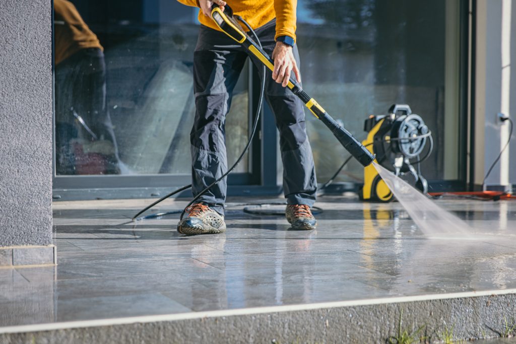 Man cleaning the terrace with high pressure cleaner
